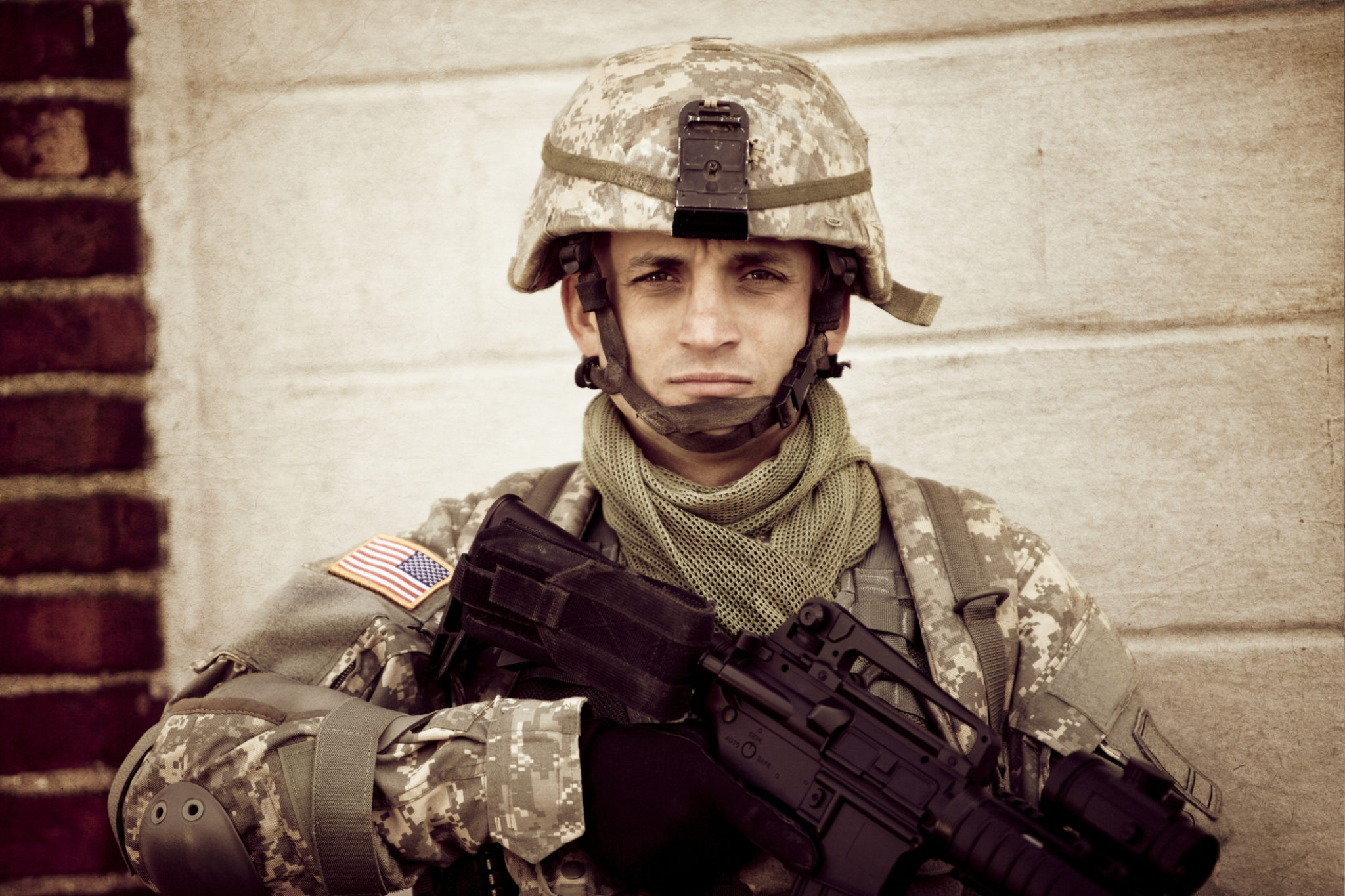 American soldier in full combat gear looking at the camera. Soldiers cannot simply shut off their memories of combat. PTSD symptoms can be treated through online therapy in Ohio. 