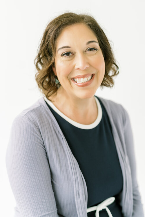 Christina in a blue dress and gray sweater. Work with an experienced Trauma Therapist in Ohio today.