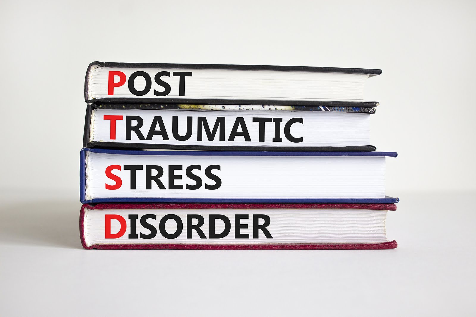 A stack of books with the words Post Traumatic Stress Disorder on them sit on a white surface. There are several ways to treat PTSD effectively. Our PTSD therapists in Ohio specialize in PTSD treatment and are here to help.