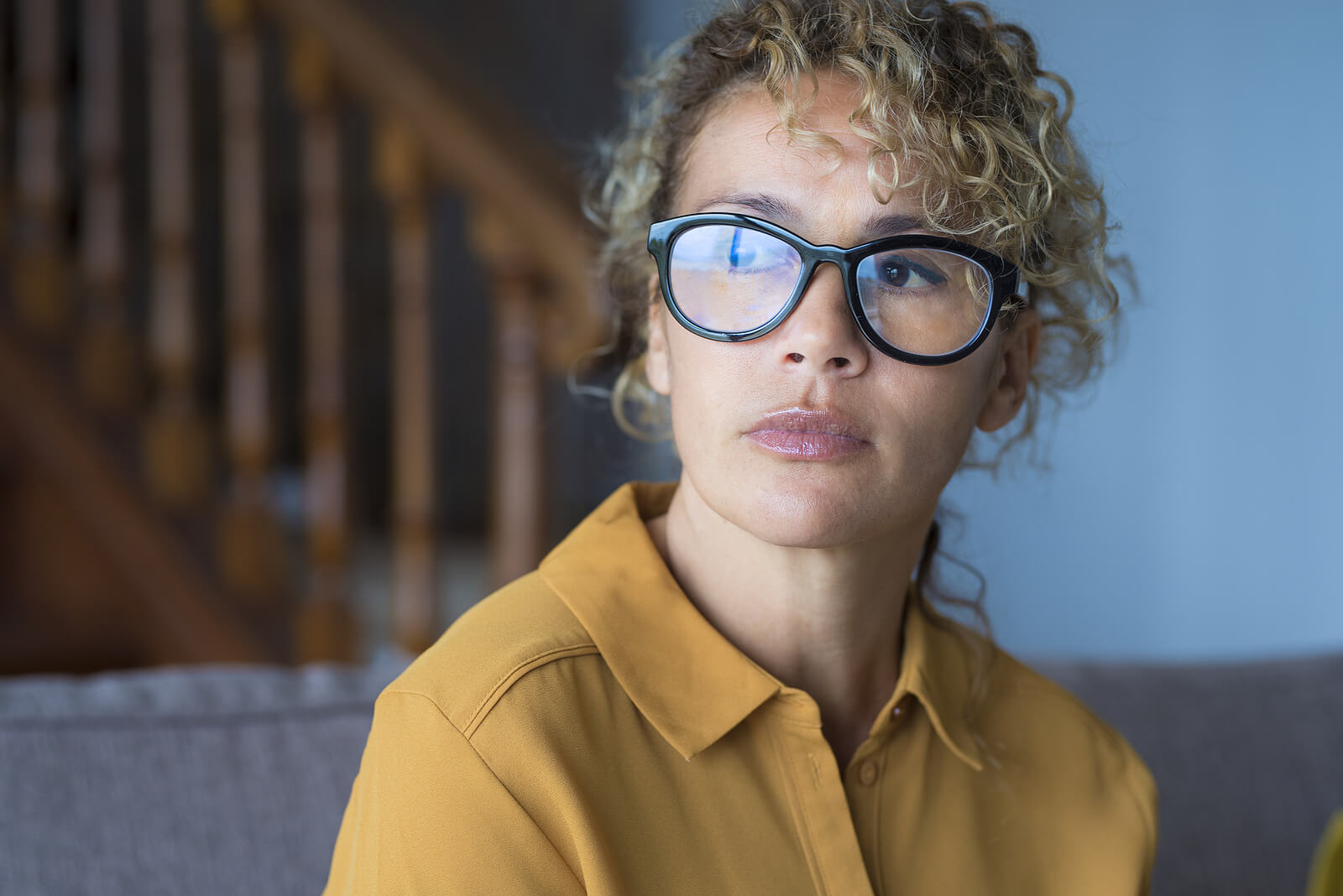 Close up of woman in yellow with black glasses. Feeling normal again after sexual assault can seem like an impossibility, but sexual assault survivors in Ohio can use online therapuy to regain a sense of normalcy.