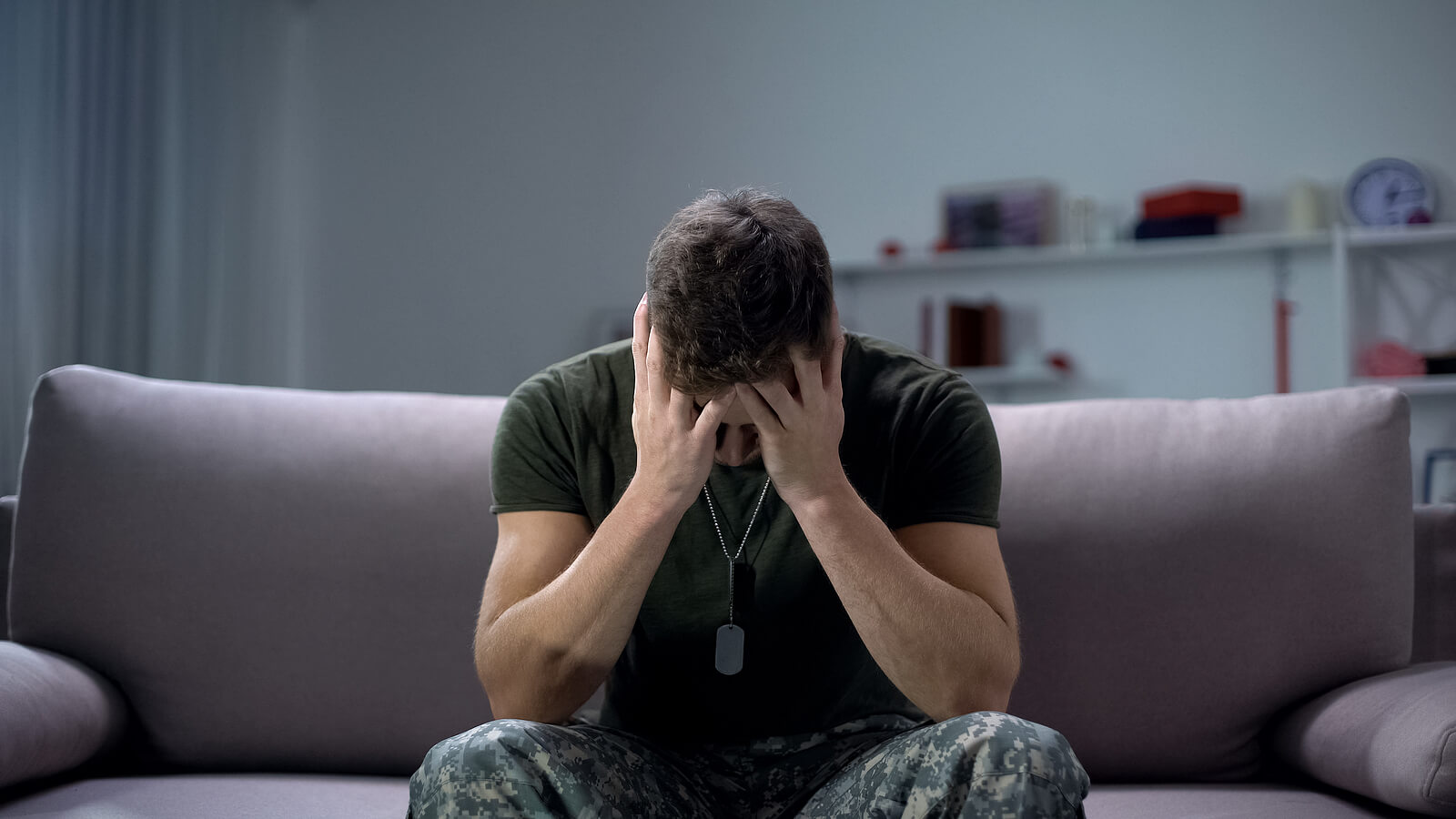 Marine sits with head in hands looking at the floor. Combat vets cannot erase painful combat memories but they can learn to overcome them with online PTSD therapy in Ohio and Kentucky.