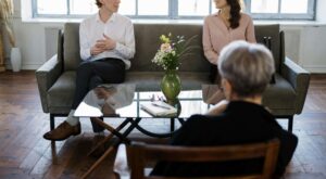 A couple sits across from a therapist in a calm counseling space, representing the healing power of trauma-focused therapy services in Ohio. This setting is ideal for those navigating survivors guilt in Ohio or working with a grief counselor in Ohio. 