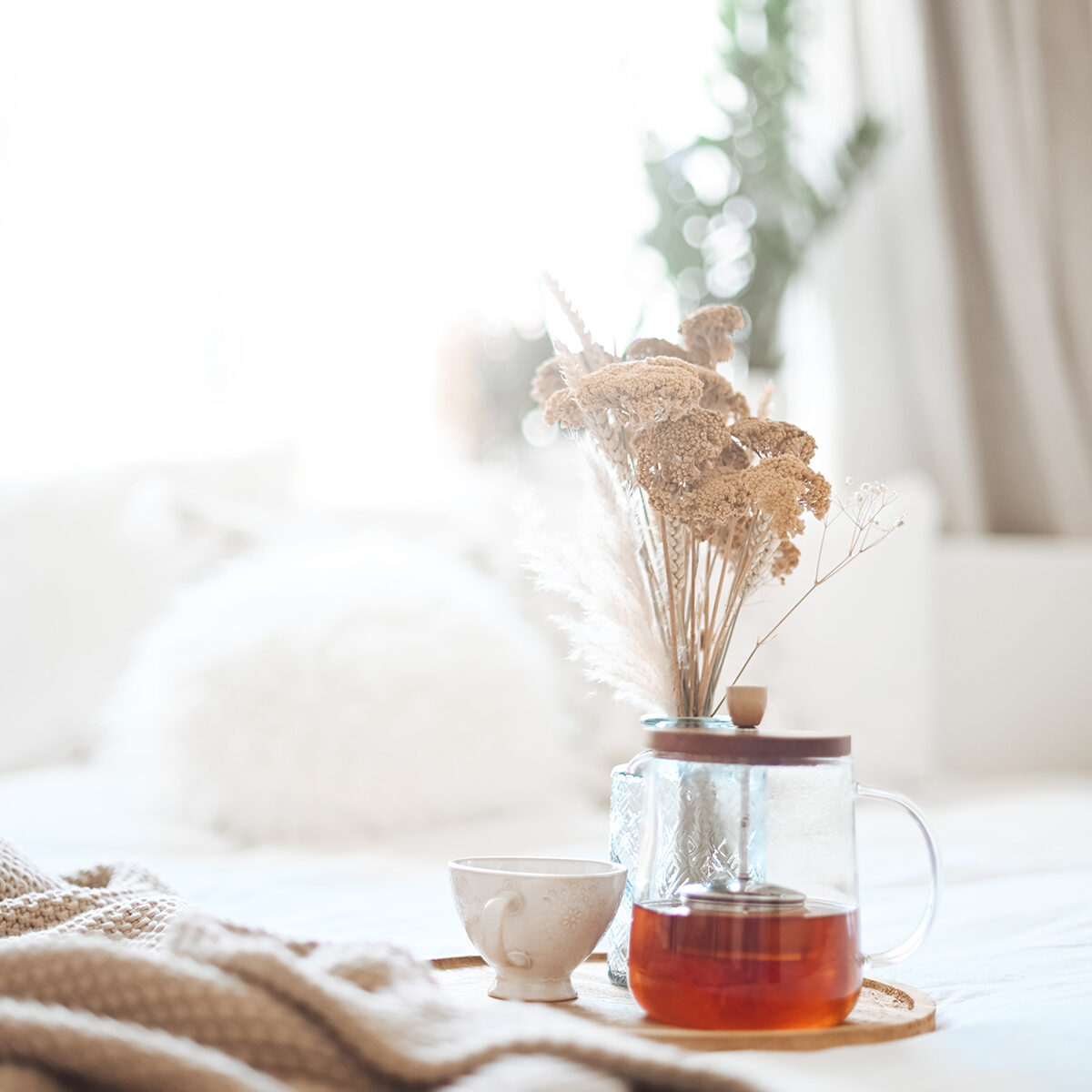 Tea pot and cup of tea sitting on a platter next to a blanket representing the comfort and peace that can be found with Therapy for Sexual Assault Survivors in Ohio.