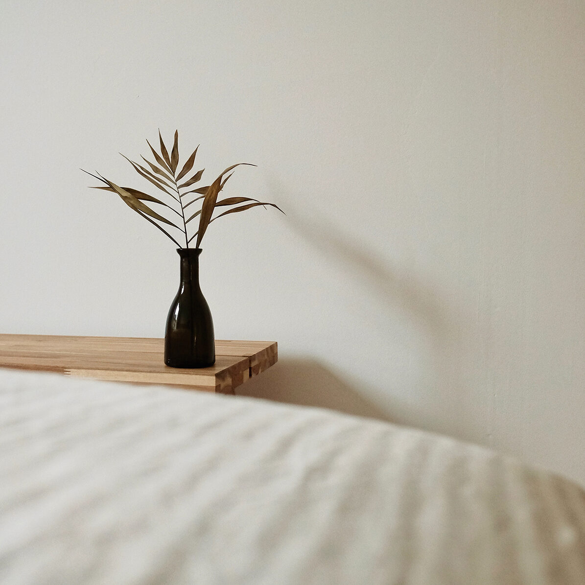 Greenery setting in a vase on a bedside table. Learn the skills to face and overcome childhood trauma with Therapy for Childhood Trauma Survivors in Ohio and start living your best life.